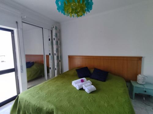 アルマカオ・デ・ペラにある1P Torre Sol Casas & Papeisのベッドルーム1室(緑色のベッド1台、タオル付)