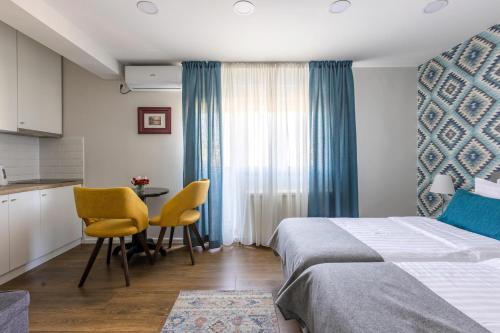 ein Hotelzimmer mit einem Bett, einem Tisch und Stühlen in der Unterkunft Apartment Sovre in Belgrad