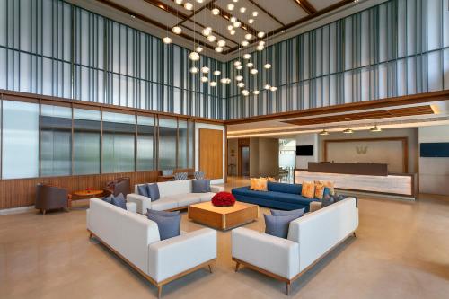 a lobby with couches and chairs and a piano at Welcomhotel by ITC Hotels, Ashram Road, Ahmedabad in Ahmedabad