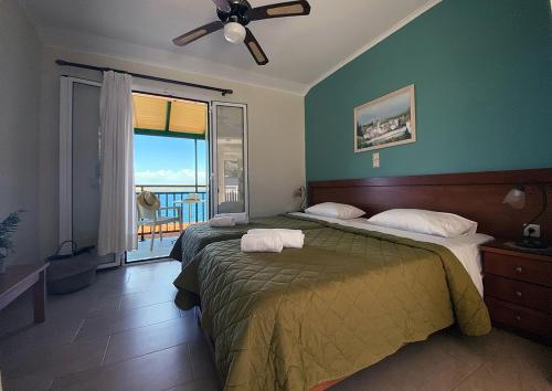a bedroom with a large bed and a balcony at THEKLI STUDIOS in Argostoli