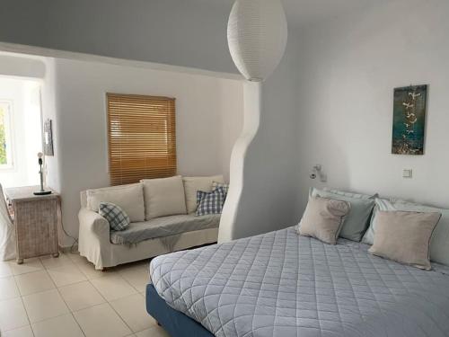 a bedroom with a bed and a couch at Nefeli Sea View Holiday House in Mýkonos City