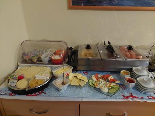 a buffet with cheese and other food on a table at Hotel Pension Neptun in Ueckeritz