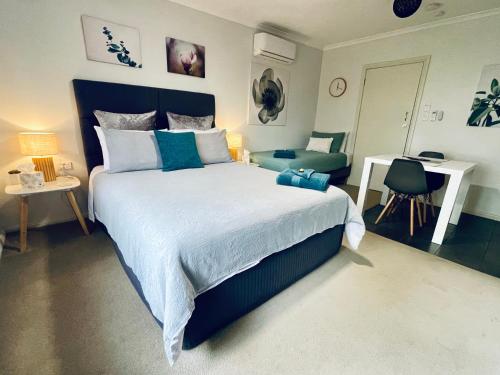 ein Schlafzimmer mit einem großen Bett und einem Schreibtisch in der Unterkunft Emu Retreat B&B in Tailem Bend