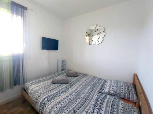 une chambre avec un lit et une horloge au mur dans l'établissement T2 vue centre ville -Le viking 50m mer, à La Grande Motte