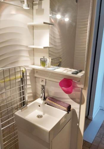 une salle de bain blanche avec un lavabo et un miroir dans l'établissement T2 vue centre ville -Le viking 50m mer, à La Grande Motte