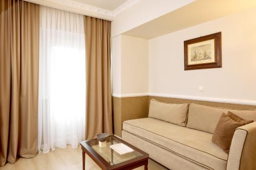 a living room with a couch and a table at Grand Hotel Palace in Thessaloniki