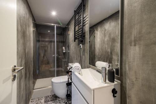 a bathroom with a sink and a toilet and a shower at Camellia Garden in Porto
