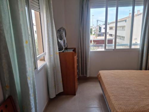 a bedroom with a bed and a window with a view at Pareado Mediterrania in Benicarló