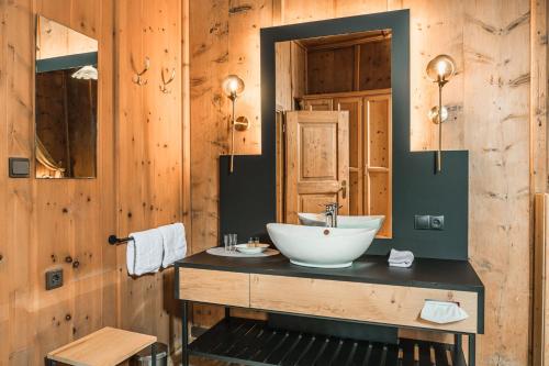 baño con lavabo y pared de madera en Ansitz Zehentner, en Laion