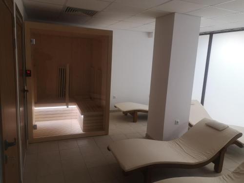 Habitación con silla y puerta corredera de cristal en QUEEN'S VIEW app-9 free pool,parking, fitness & sea view en Balchik