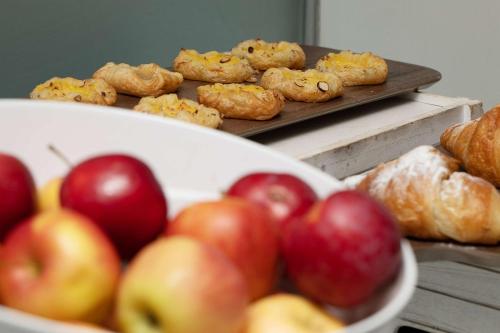 a table with a bowl of apples and pastries at Ramada Encore Leicester City Centre in Leicester
