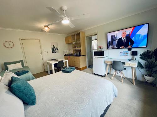 a bedroom with a large bed and a flat screen tv at Emu Retreat B&B in Tailem Bend