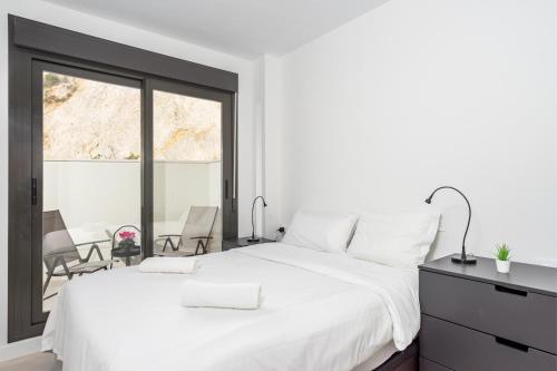 Un dormitorio blanco con una cama grande y una ventana en Modern apartment with pool in Benalmadena Ref 47, en Benalmádena