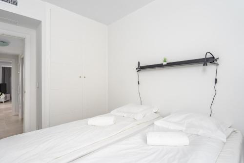 1 dormitorio blanco con 2 almohadas blancas en una cama en Modern apartment with pool in Benalmadena Ref 47, en Benalmádena