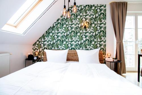 a bedroom with a large white bed with a green wall at Meer Komfort Mariendorf in Mariendorf