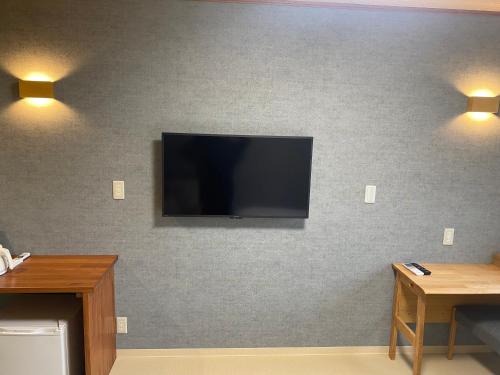 a flat screen tv mounted on a wall with lights at ETAVIA Yufuinekimae in Yufuin