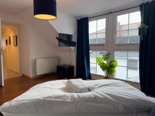 sypialnia z białym łóżkiem i dużym oknem w obiekcie Design Wohnung nähe Uni w Koblencji