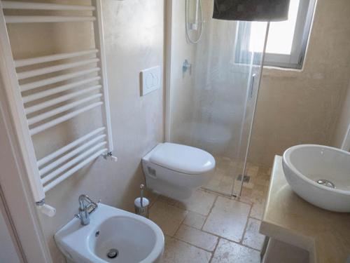 y baño con aseo, lavabo y ducha. en Tramonti d'Itria, en Ostuni