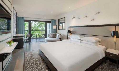 a bedroom with a large white bed and a living room at Hyatt Regency Phuket Resort - SHA Extra Plus in Kamala Beach