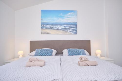 ein Schlafzimmer mit einem großen weißen Bett mit zwei Kissen in der Unterkunft Queen's Lodge Mastrinka in Trogir