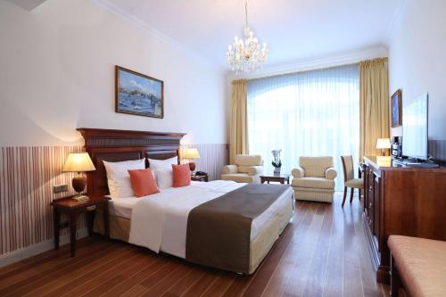 a hotel room with a bed and a chandelier at ATLANTIC Grand Hotel Travemünde in Travemünde
