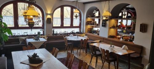 um restaurante com mesas, cadeiras e janelas em Drachenburg em Marktbreit