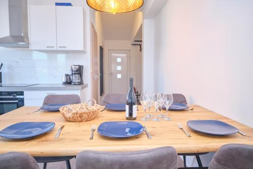 un tavolo in legno con piatti blu e bicchieri da vino di Queen's Lodge Mastrinka a Trogir