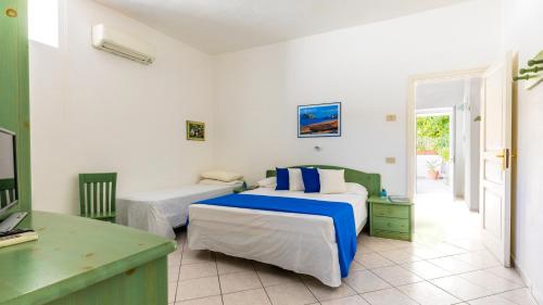 a hotel room with two beds and a desk at Lucia Maison in Ischia