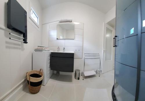 cocina blanca con fregadero y encimera en Appartement cosy climatisé à Sarlat, en Sarlat-la-Canéda