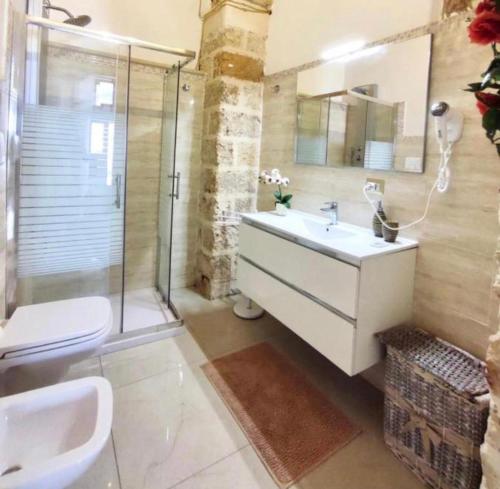 a bathroom with a sink and a shower and a toilet at Corte Merlata Apartments in Galatone