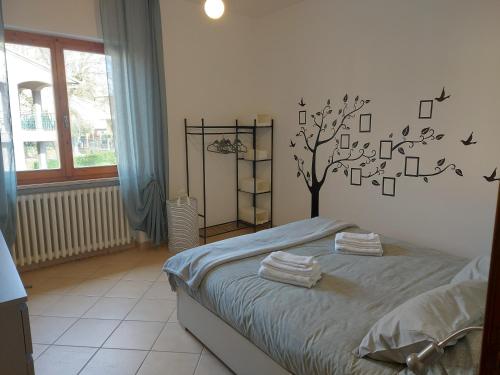 a bedroom with a bed with a tree on the wall at dimorafelice.sarteano in Sarteano
