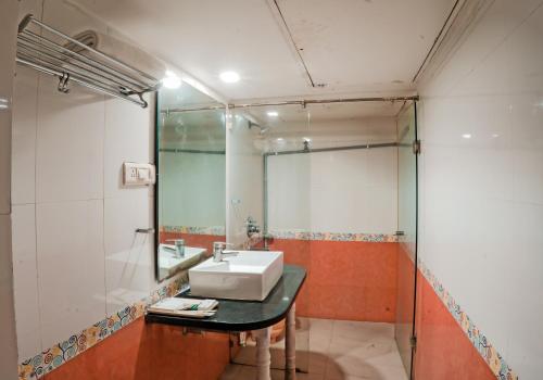 a bathroom with a sink and a mirror at Pleasure Inn in Bhopal