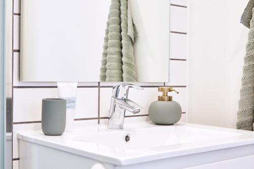 athome apartments في أُرهوس: منضدة الحمام مع الحوض والمرآة