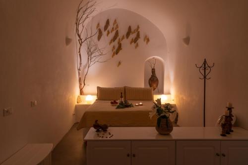 a bedroom with a bed with a tree mural on the wall at Lithies Traditional Homes in Firostefani