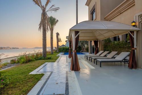 a patio with chairs and an umbrella on a house at Maison Privee - Exclusive Villa with Private Pool, Garden & Beach in Dubai