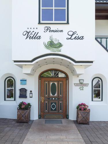 a building with a wooden door in front of it at Alpen Glück Hotel Villa Lisa garni in Kirchberg in Tirol