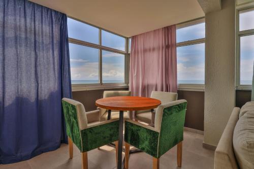 a dining room with a table and chairs and windows at Shangri-La Self Catering Holiday Apartment in Kingsburgh
