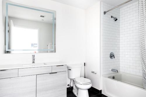 y baño blanco con aseo, lavabo y bañera. en Somerville 1BR w Gym Doorman nr Assembly Row BOS-230, en Somerville