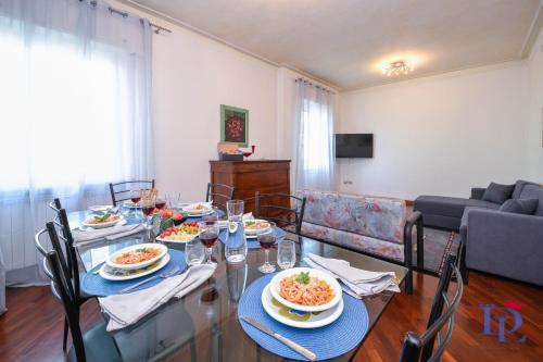 uma sala de jantar com uma mesa com pratos de comida em DesenzanoLoft Villa Palm Garda Beach, with garden, barbecue and pool em Desenzano del Garda