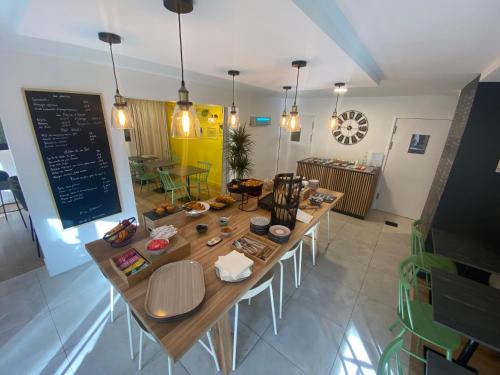 a dining room with a large wooden table and chairs at Campanile Nantes ~ Rezé Aéroport in Rezé