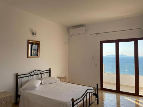 a bedroom with a bed and a view of the ocean at Vila Dena in Vlorë