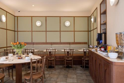 a restaurant with tables and chairs and a bar at Hotel Michelet Odeon in Paris