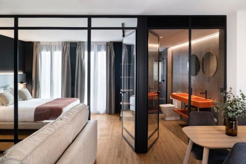 セビリアにあるMagno Apartments Castillaのベッドとバスルーム付きのホテルルームです。