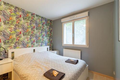 um quarto com uma cama e um papel de parede florido em ZenBNB / Tournelles / Jardin Privé / Hyper-Centre em Annemasse