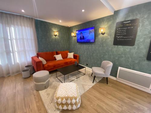 sala de estar con sofá y TV en la pared en Campanile Nantes ~ Rezé Aéroport en Rezé