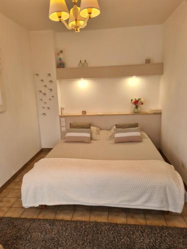 une chambre avec un grand lit et un lustre dans l'établissement Villa Hélios, à Canet