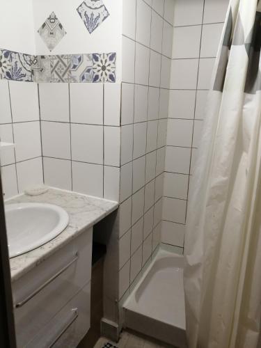 une salle de bain blanche avec un lavabo et une douche dans l'établissement La Crèche Wimille / Wimereux, à Wimille