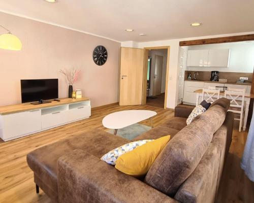sala de estar con sofá marrón y cocina en Stadtzimmer im Entenmoos en Bad Waldsee