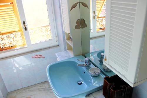 een badkamer met een blauwe wastafel en een spiegel bij Casa Gerry vista mare in Levanto