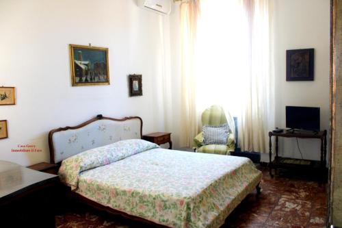 een slaapkamer met een bed, een stoel en een raam bij Casa Gerry vista mare in Levanto